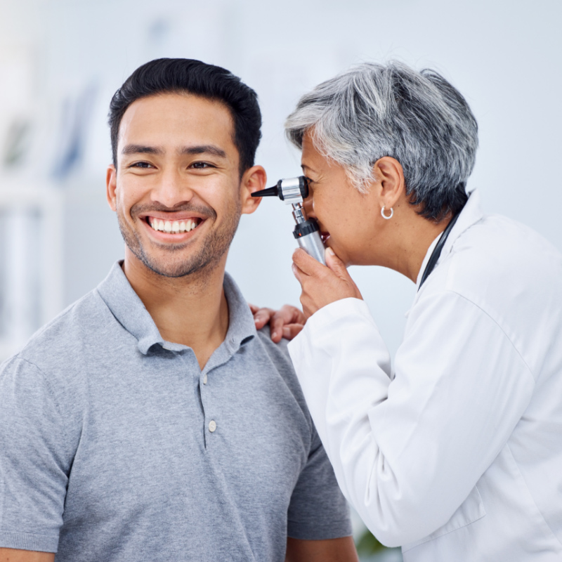 A doctor examining a patient’s ear with an otoscope during an ENT check-up”